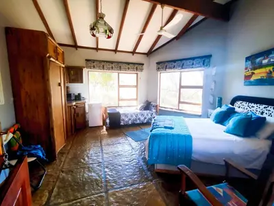 a bedroom with a large bed in a room at Pumba's Den Kranspoort in Winterkamp