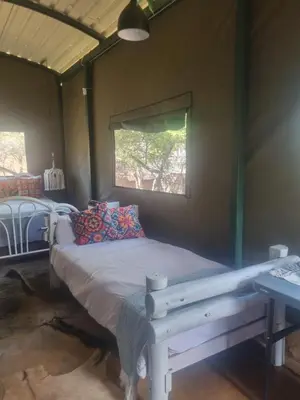 a bed in a room with a window at Pumba's Den Kranspoort in Winterkamp