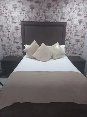a bed with white pillows on top of it at Makhasana