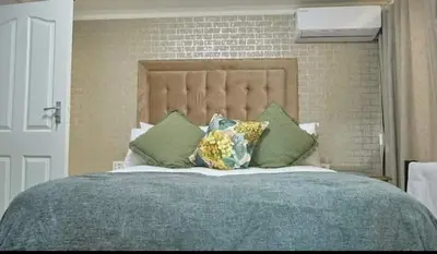 a bedroom with a large bed with pillows on it at Makhasana