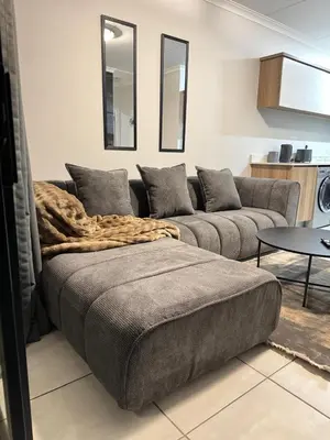 a living room with a couch with a blanket on it at The Dream Stay At The Blyde - Suite 3 in Pretoria