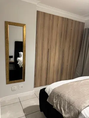 a bedroom with a bed and a large mirror at The Dream Stay At The Blyde - Suite 3 in Pretoria