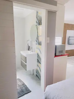 a white bathroom with a sink and a mirror at The Airport Terminal Guesthouse in Kempton Park