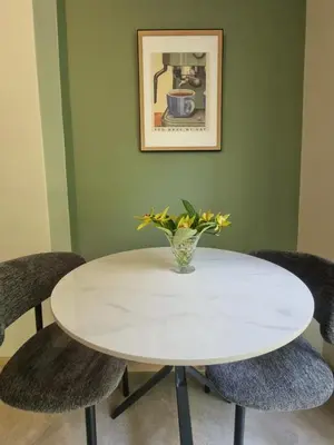 a white table with chairs and a vase with flowers at Edward suites ,Apartment 2 in Pretoria