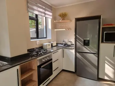 a kitchen with a stove and a refrigerator at Edward suites ,Apartment 2 in Pretoria