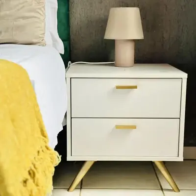 a white nightstand with a lamp on it next to a bed at Dula Bonolo Lodge in Lebaleng