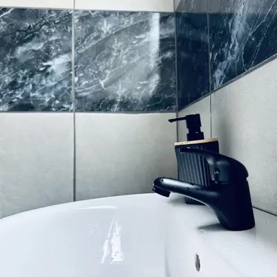 a black faucet on top of a sink in a bathroom at Dula Bonolo Lodge in Lebaleng