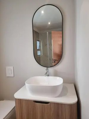 a bathroom with a white sink and a mirror at Edward Suites, Apartment 1 in Pretoria