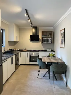 a kitchen with a table and chairs in it at Edward Suites, Apartment 1 in Pretoria