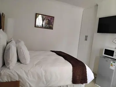 a bedroom with a bed with a teddy bear on it at Best Enough Guesthouse in Pretoria