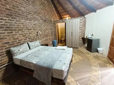 a bedroom with a bed in a brick wall at Lapa Moyo Safari's in Linton