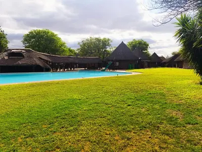 a resort with a swimming pool and thatched roofs at Lapa Moyo Safari's in Linton
