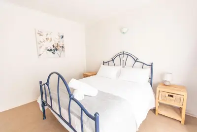 a bedroom with a white bed with a blue frame at 28 Schalk drive in Polokwane