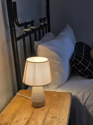 a lamp on a wooden table next to a bed at 28 Schalk drive in Polokwane