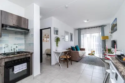 a kitchen and living room with a couch and a table at Willow House Oasis - Your Haven in Kempton Park