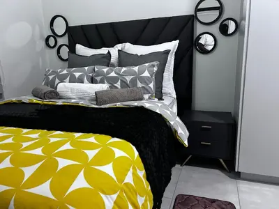 a bedroom with a bed with a yellow and white comforter at The Blyde blue lagoon in Pretoria