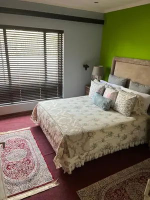 a bedroom with a bed and a green wall at Nzwaki Self Catering in Nelspruit
