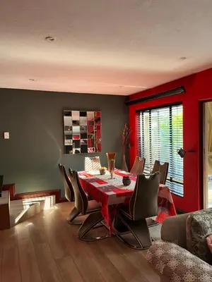 a dining room with a red table and chairs at Nzwaki Self Catering in Nelspruit