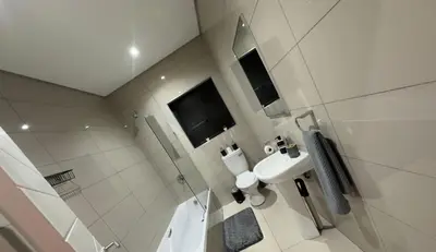 a white bathroom with a sink and a toilet at Guestnest in Mokopane