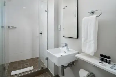a white bathroom with a sink and a shower at Stay Menlyn - Luxe Apartment 617 in Pretoria
