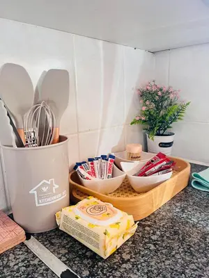 a counter with a tray of utensils and a container of cheese at Intsika apartments in Nelspruit