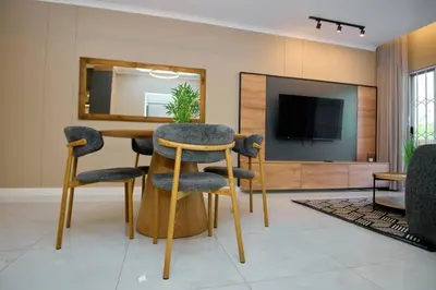 a living room with a table and chairs and a television at Unit 203 at Glen Park in Pretoria