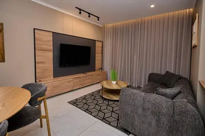 a living room with a tv and a couch and a table at Unit 203 at Glen Park in Pretoria