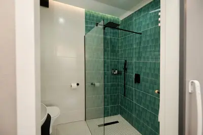 a bathroom with a shower with green tile at Unit 203 at Glen Park in Pretoria