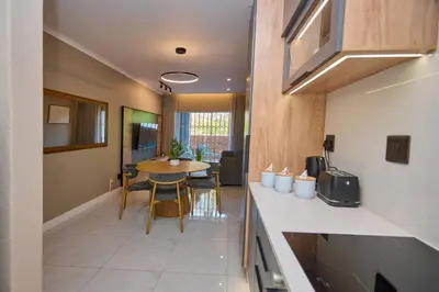 a kitchen and dining room with a table in a room at Unit 203 at Glen Park in Pretoria