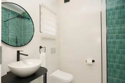 a white bathroom with a sink and a mirror at Unit 203 at Glen Park in Pretoria