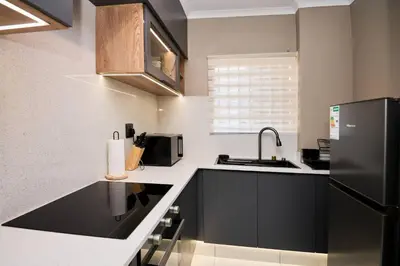 a kitchen with a sink and a black refrigerator at Unit 203 at Glen Park in Pretoria