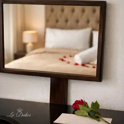 a mirror on a wall with a bed in a room at La Dukes Resort in Bushman Rock