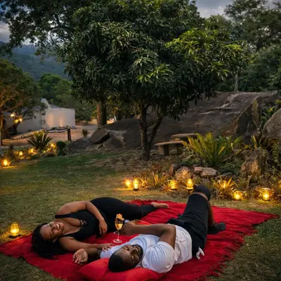 two people laying on a blanket in the grass at La Dukes Resort in Bushman Rock