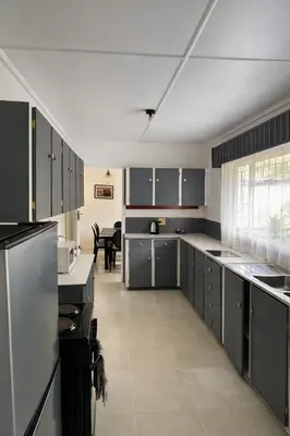 a large kitchen with gray cabinets and a table at La Dukes Resort in Bushman Rock