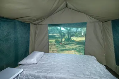 a bedroom with a bed in a tent at Die BosKamp - Hartbeespoort Dam in Hartbeespoort