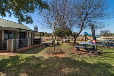 a park with picnic tables and a playground at Die BosKamp - Hartbeespoort Dam in Hartbeespoort