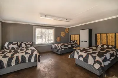 a bedroom with two beds and a window at Die BosKamp - Hartbeespoort Dam in Hartbeespoort