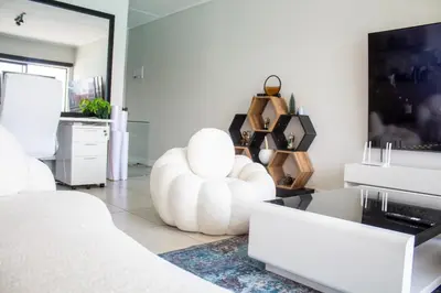 a living room with a white couch and a chair at Time Oon Travel And Tour Unit 754 Luxurious in Pretoria