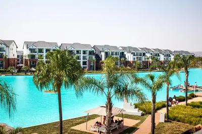 a large swimming pool with palm trees and condos at Time Oon Travel And Tour Unit 754 Luxurious in Pretoria
