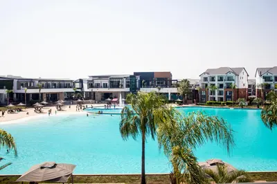 a large swimming pool with palm trees and buildings at Time Oon Travel And Tour Unit 754 Luxurious in Pretoria
