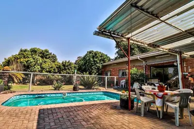a patio with a table and chairs next to a pool at 3 Bedroom House in Nelspruit in Nelspruit