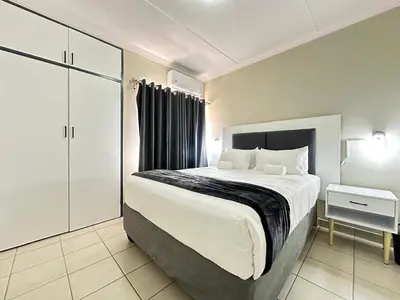 a bedroom with a large bed and a night stand at 3 Bedroom House in Nelspruit in Nelspruit
