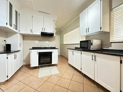 a large kitchen with white cabinets and appliances at 3 Bedroom House in Nelspruit in Nelspruit