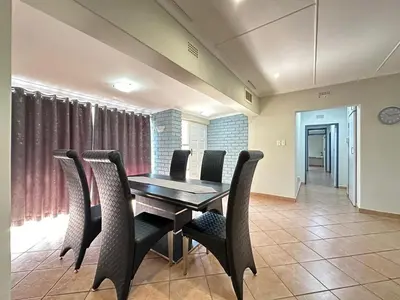 a dining room with a wooden table and chairs at 3 Bedroom House in Nelspruit in Nelspruit
