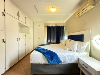 a bedroom with a large bed with white cabinets at 3 Bedroom House in Nelspruit in Nelspruit