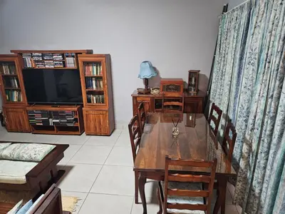 a dining room with a wooden table and a television at Luxury Meets Convenience Near City & Travel Links in Pretoria