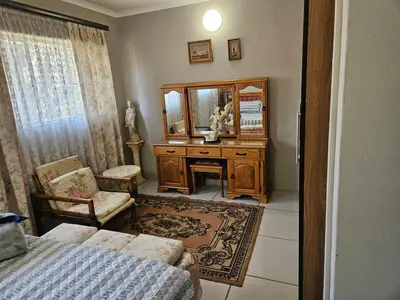 a bedroom with a desk and a mirror and a bed at Luxury Meets Convenience Near City & Travel Links in Pretoria