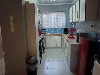 a kitchen with white cabinets and a large window at Luxury Meets Convenience Near City & Travel Links in Pretoria