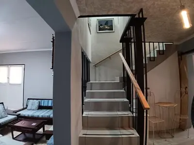 a spiral staircase in a living room with a couch at Luxury Meets Convenience Near City & Travel Links in Pretoria