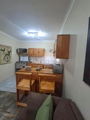 a kitchen with wooden cabinets and a counter top at Stay at Wolkeberg in Middelburg